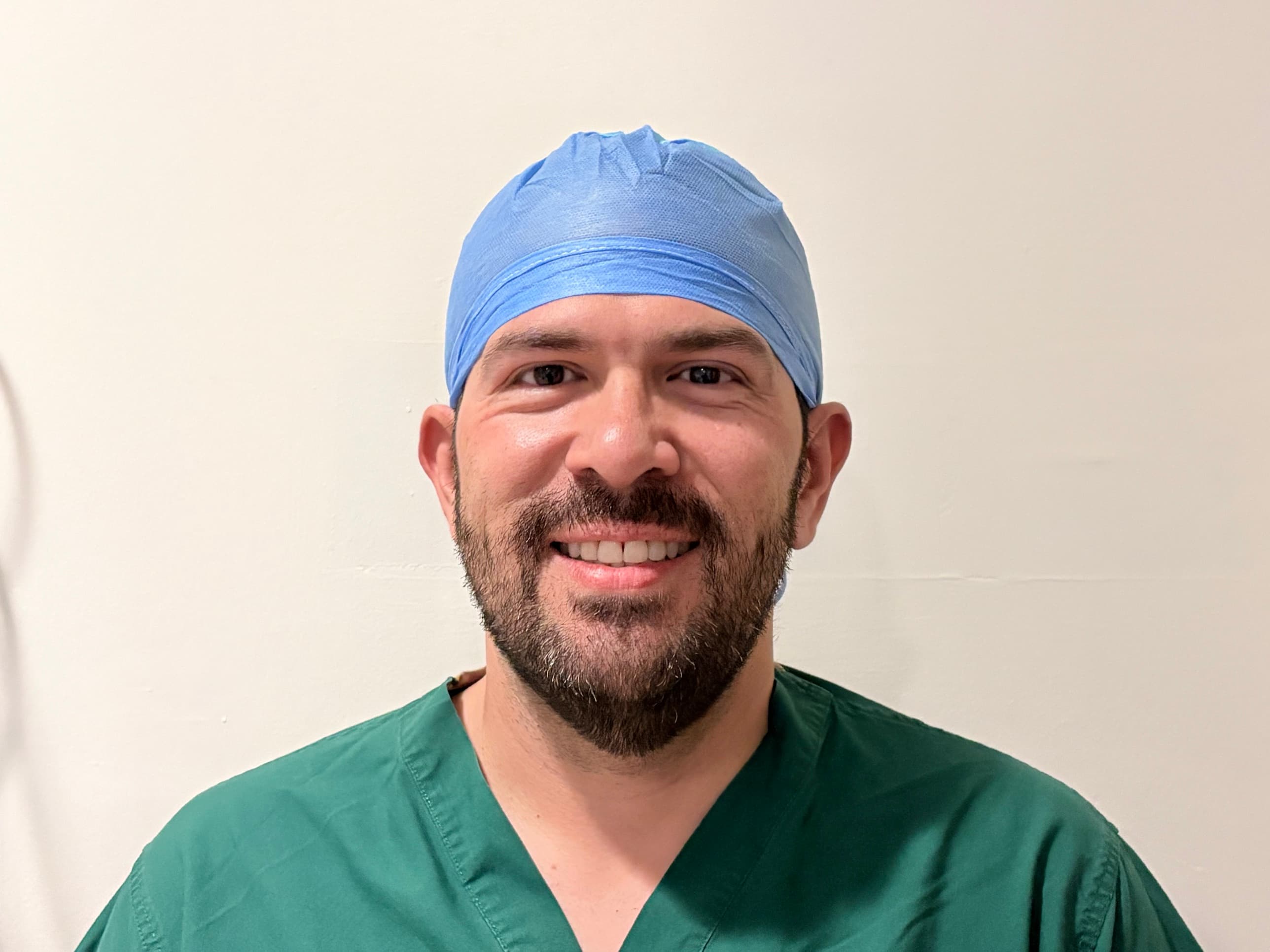 Jose David “JD” Ramos, BSN, RN, founder of Arxova, in scrubs and a surgical cap