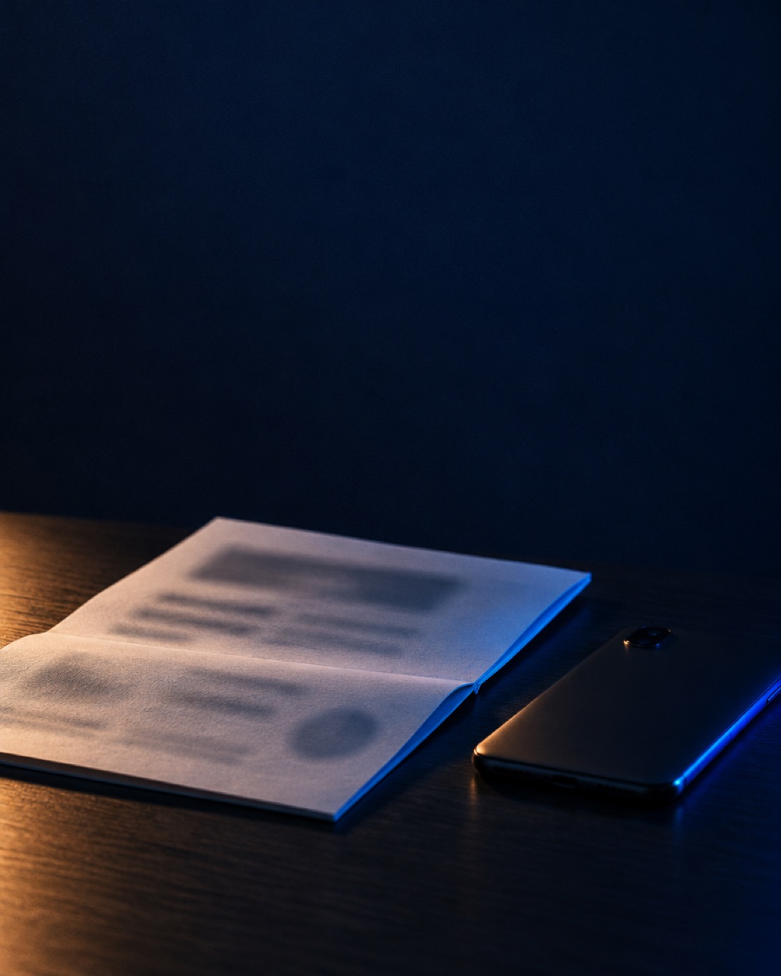 A printed record lying open on a table beside a phone
